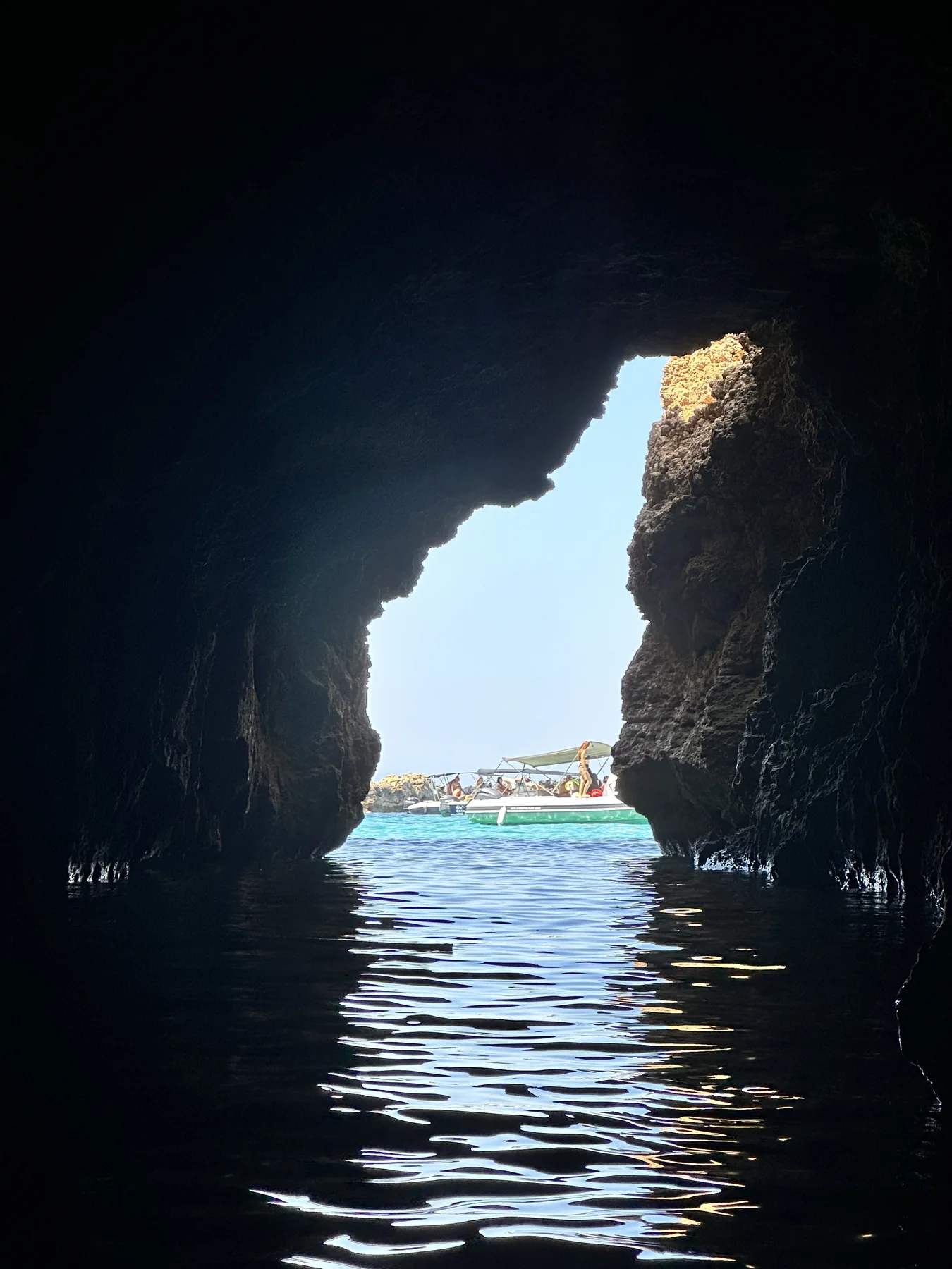 Rocky cove with clear blue water and bright coastal light.